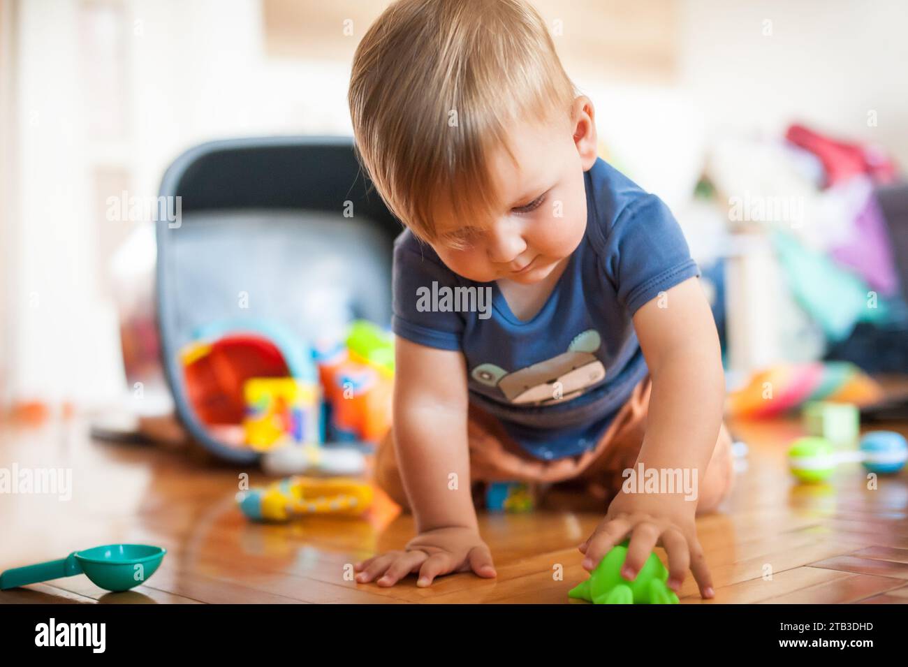 Un bambino carino che gioca con i suoi giocattoli colorati in salotto. Giocattoli educativi, sviluppo di bambini Foto Stock
