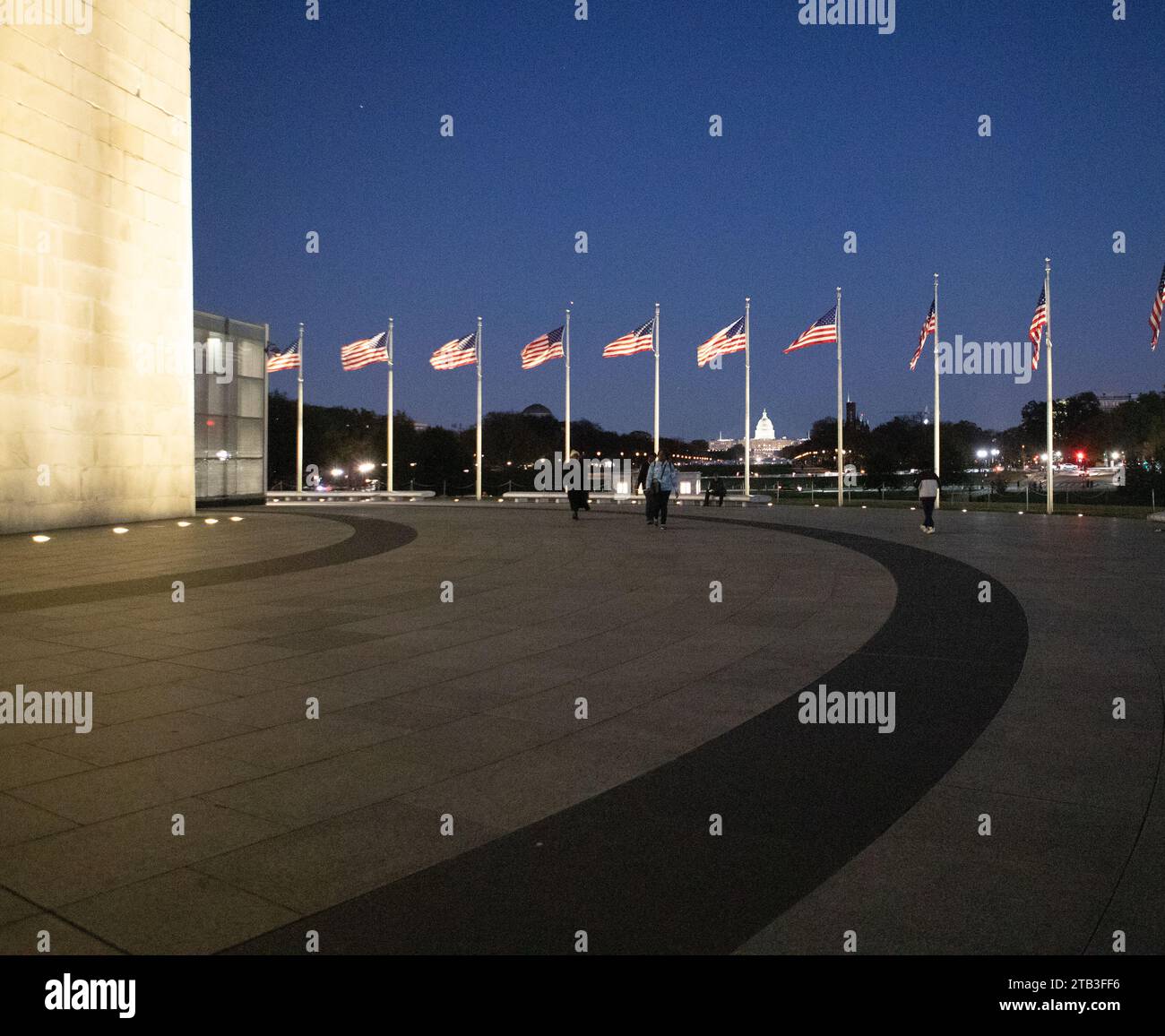 Il Washington Monument è un obelisco sul National Mall di Washington, D.C., raffigurato al crepuscolo con bandiere che lo circondano. Foto Stock