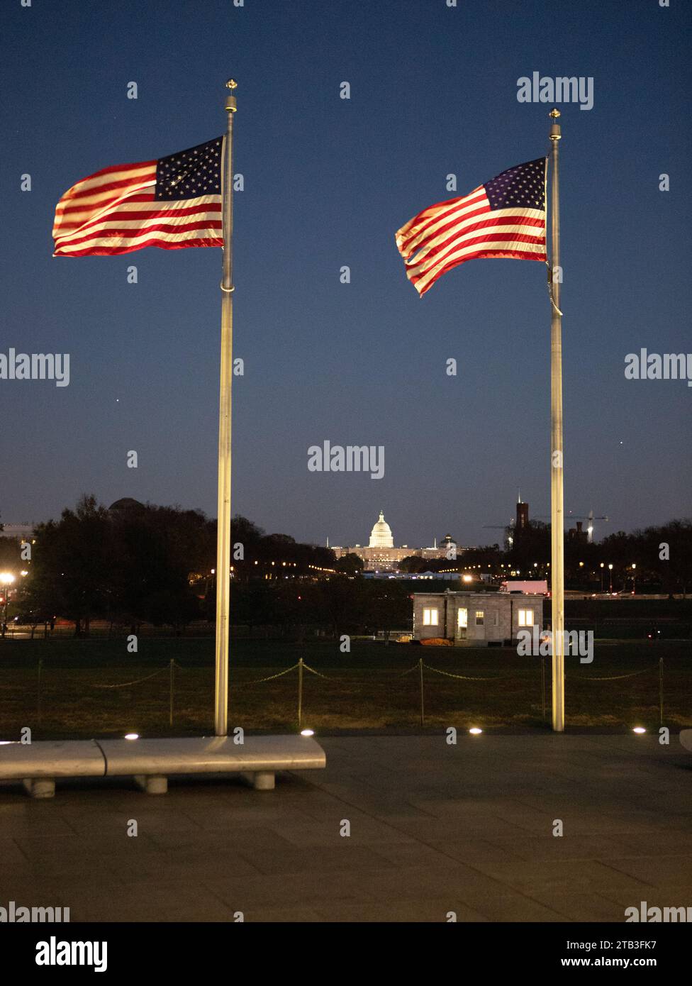 La bandiera degli Stati Uniti d'America, le stelle e le strisce, che soffiano e sventolano nel vento, su un palo della bandiera al crepuscolo Foto Stock