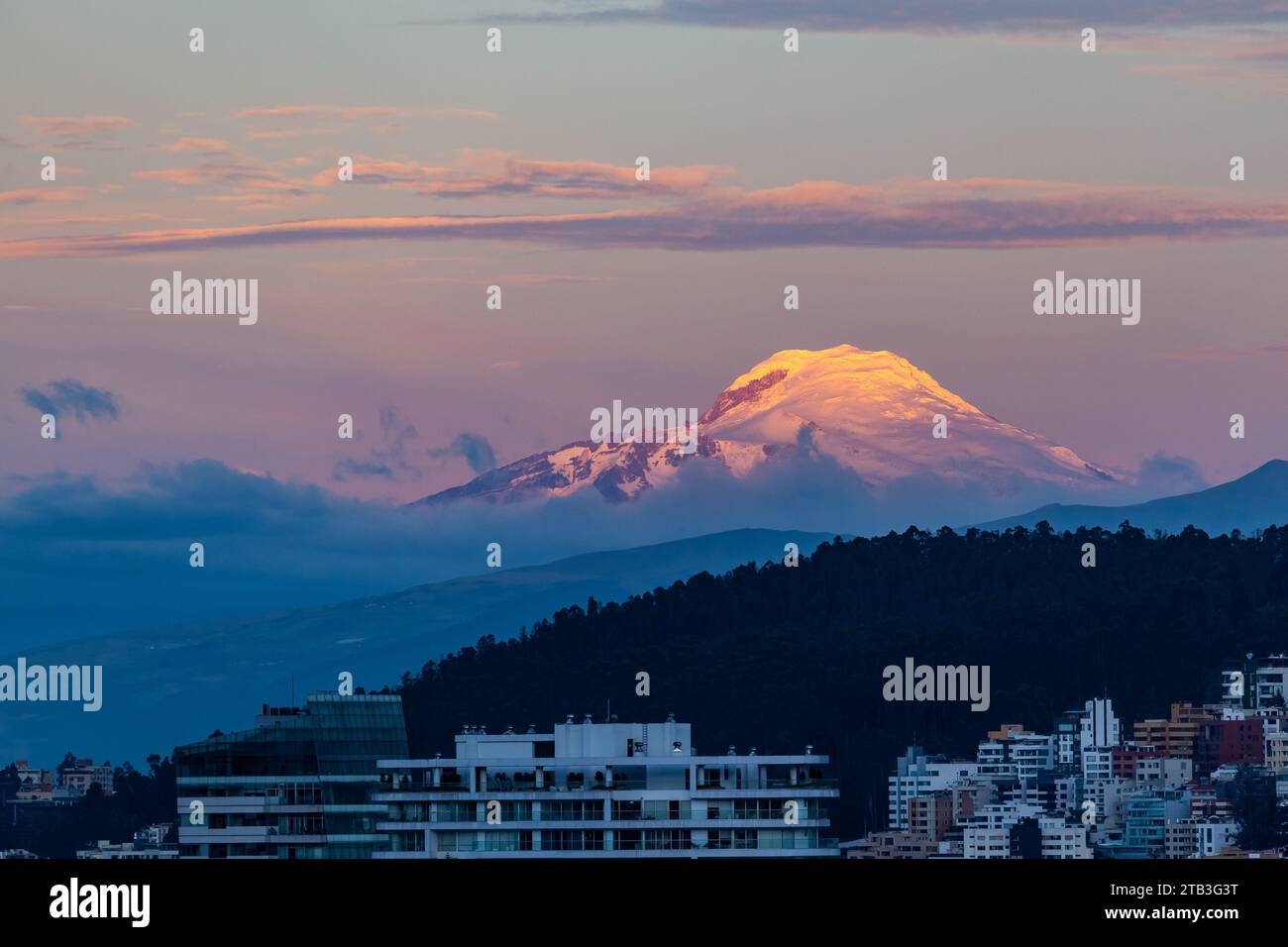 Vulcano Cayambe al tramonto con toni blu e rossi visti da Quito, Ecuador Foto Stock