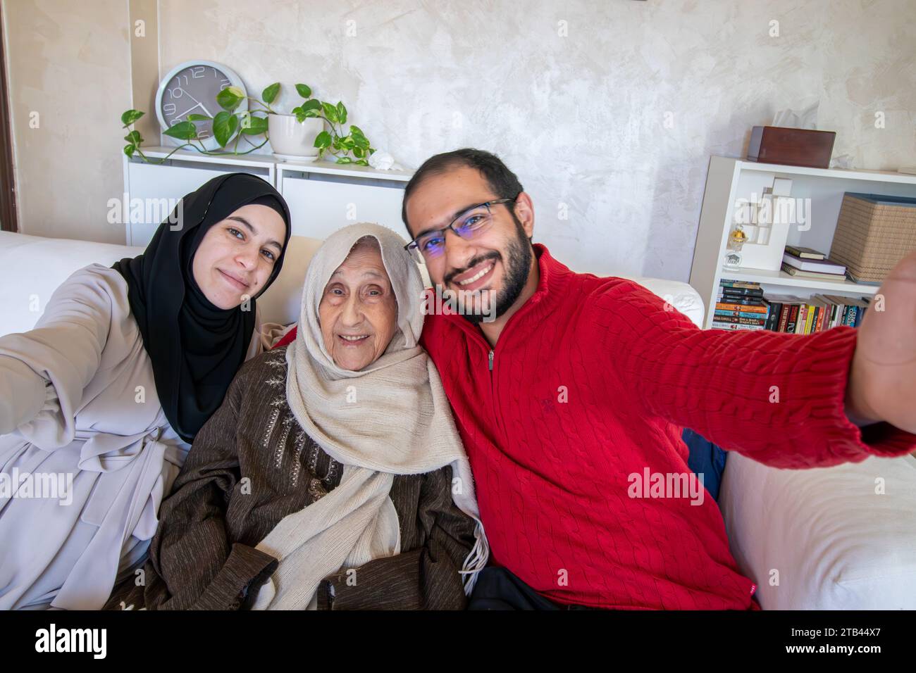 Famiglia araba che scatta selfie in casa moderna con la nonna Foto Stock
