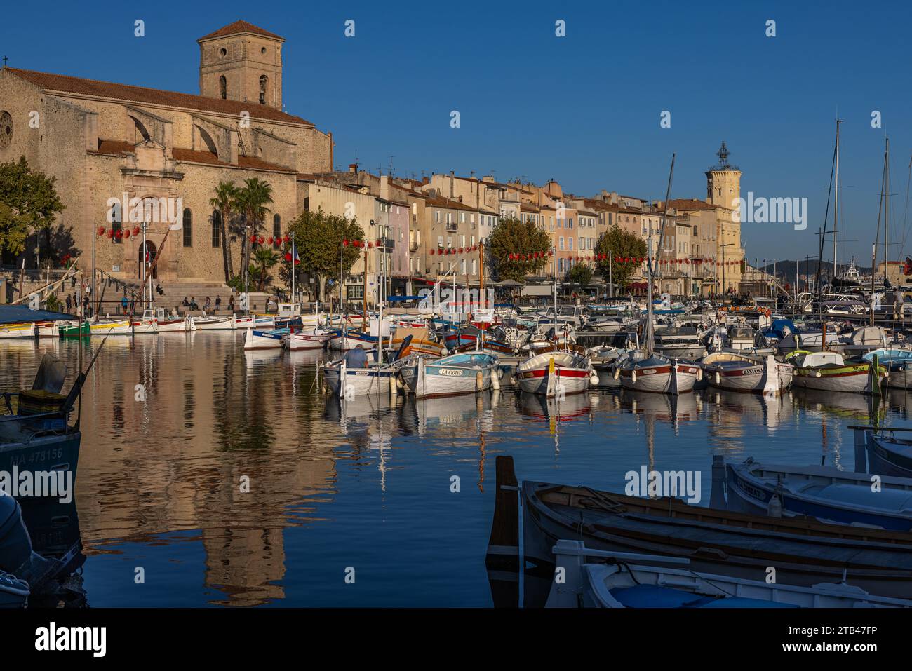 Vista del Porto Vecchio di la Ciotat che mostra barche e yacht riflessi, con la chiesa di Notre Dame de l'Assomption e il Museo di Ciotaden sullo sfondo Foto Stock