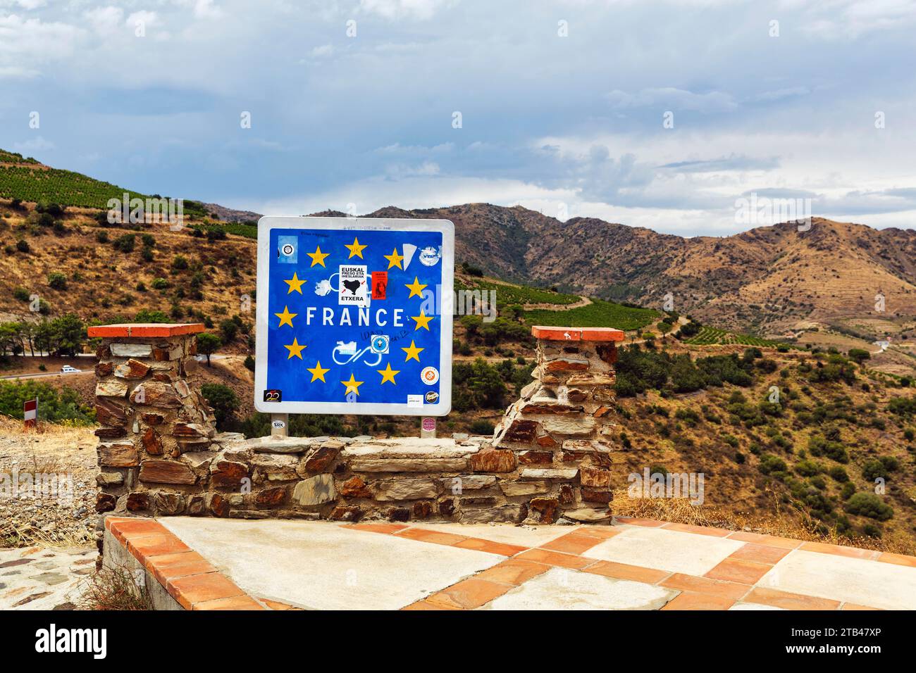 Cartello blu con stelle e adesivi europei, Unione europea, iscrizione, valico di frontiera per la Francia, valico di montagna Coll dels Beliters, strada costiera Foto Stock