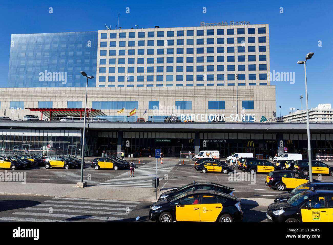 Taxi neri e gialli di fronte all'edificio della stazione, alla stazione centrale di Barcellona-Sants, a Sants-Montjuic, a Barcellona, in Spagna Foto Stock