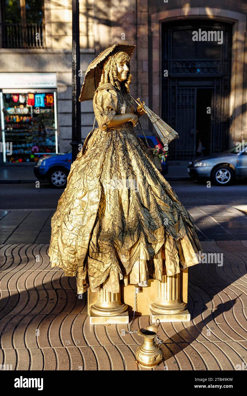 Artista di strada, mimo, statua vivente di una donna d'oro con ombrellone, centro città, Barcellona, Spagna Foto Stock