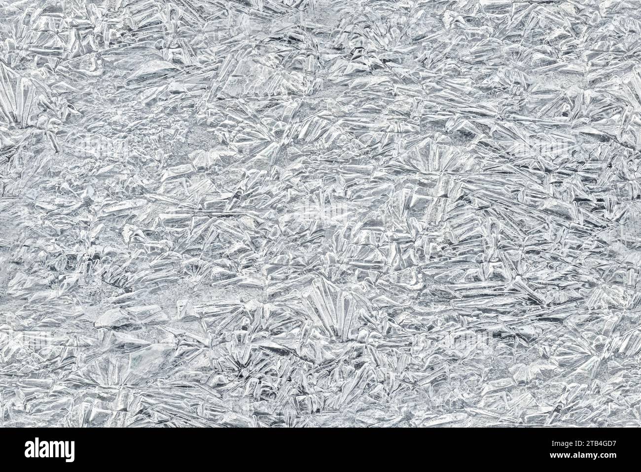 Ghiaccio su un fiume ghiacciato che forma strutture simili a cristalli, primo piano dettagli macro dall'alto - sfondo invernale astratto trasformato in una texture tagliabile senza cuciture Foto Stock
