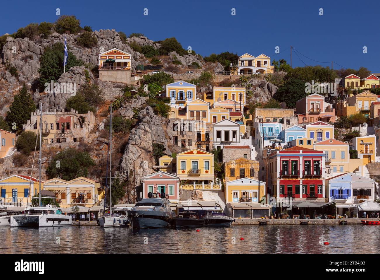 Vista delle case tradizionali colorate nel villaggio di pescatori di Symi in una giornata di sole. Grecia. Dodecaneso. Foto Stock