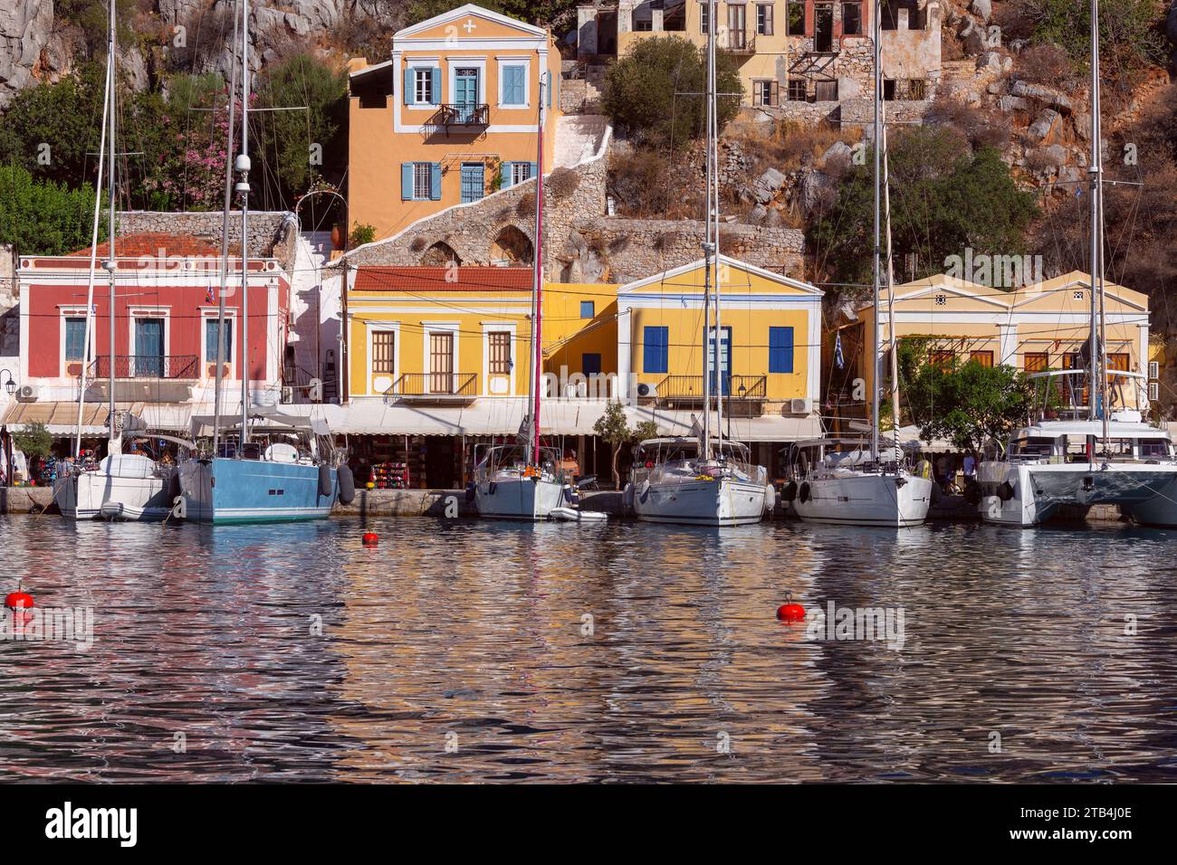Vista delle case tradizionali colorate nel villaggio di pescatori di Symi in una giornata di sole. Grecia. Dodecaneso. Foto Stock