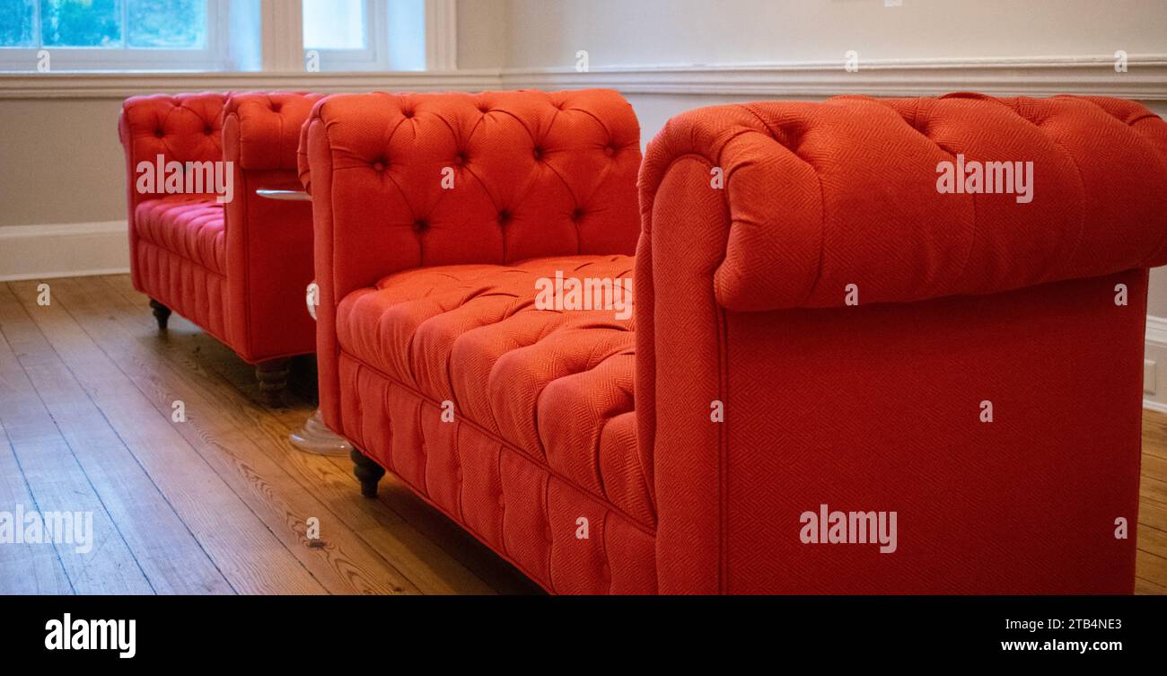 Divani con divano letto arancione in un ufficio della reception Foto Stock