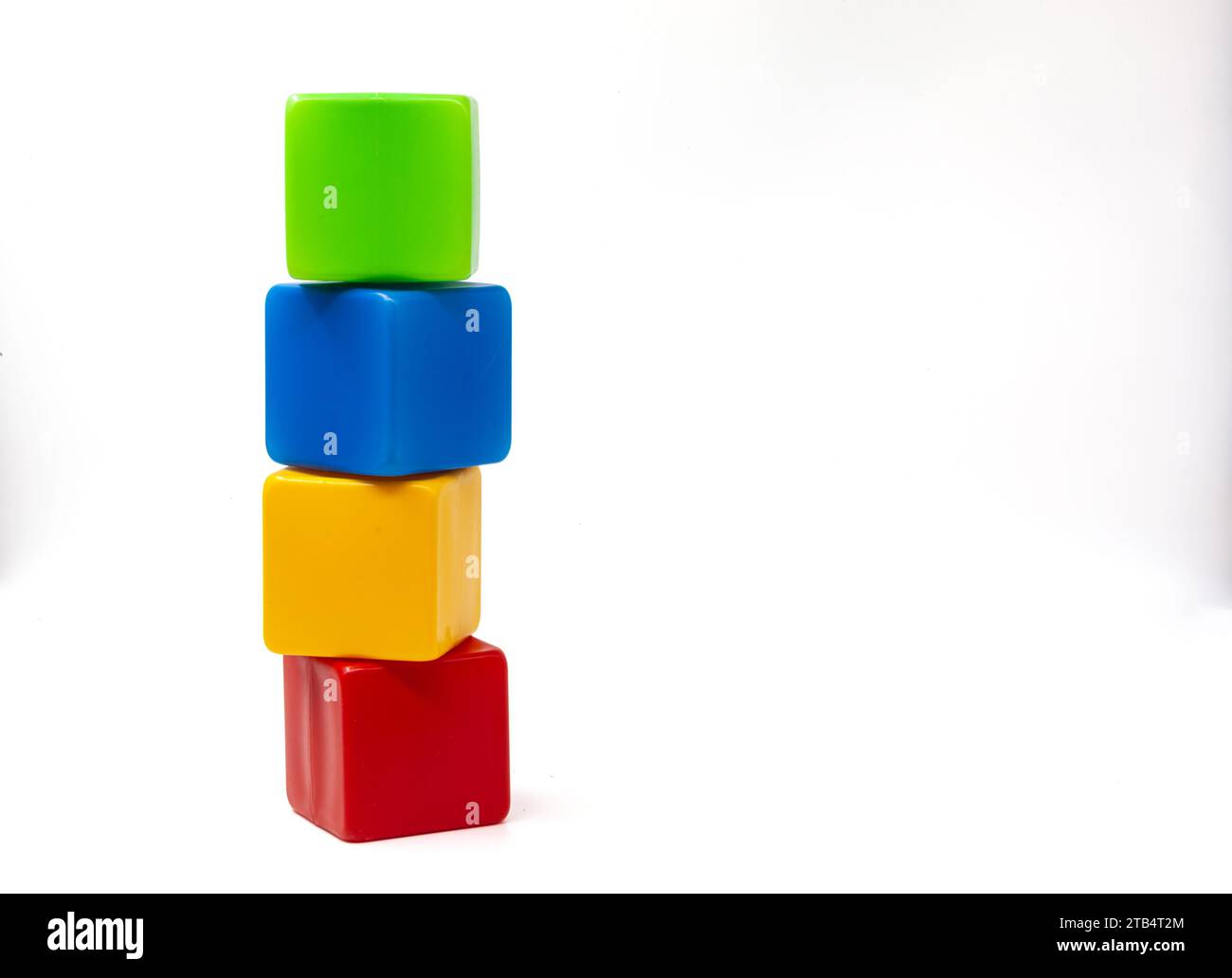 Cubi di plastica multicolore per giochi per bambini. Giallo e blu con cubetti verdi in cima al rosso. I cubi sono turbati. Uno contro uno. Foto Stock