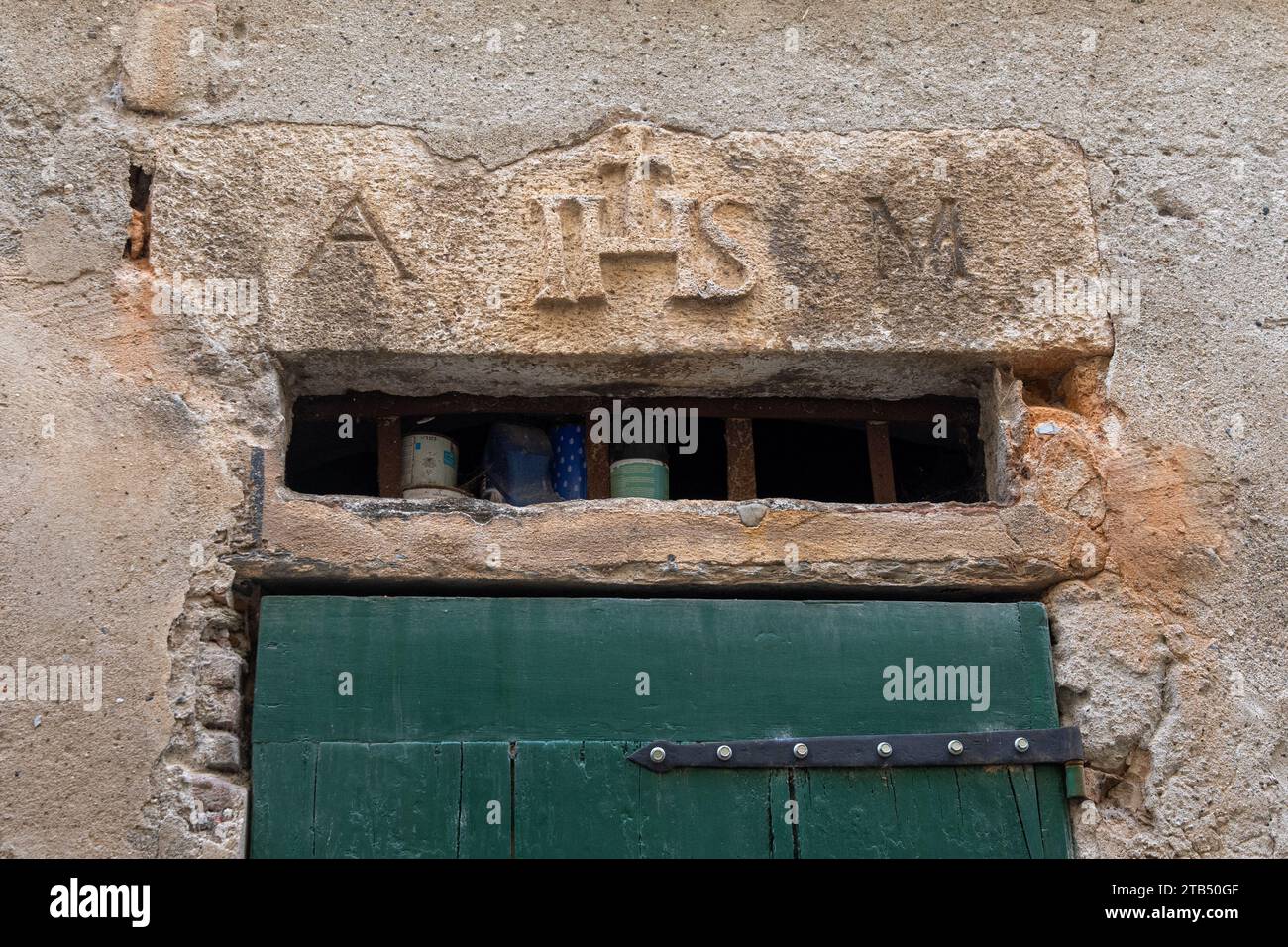 Sopra la porta incisa il simbolo religioso "IHS", un Christogram che denota le prime tre lettere del nome greco di Gesù, finale Ligure, Savona Foto Stock