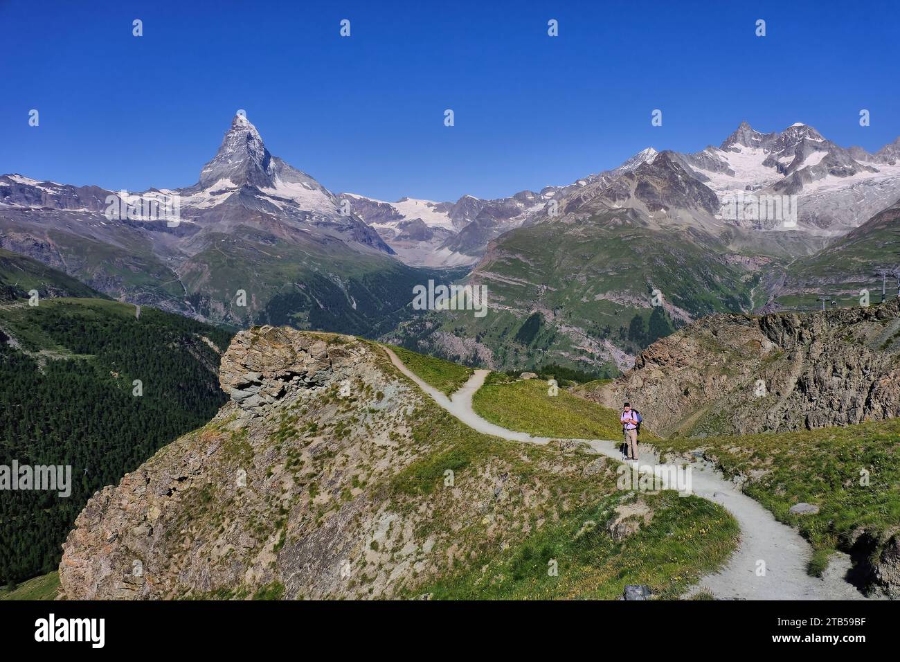 Escursionista su sentiero e Cervino con cielo nuvoloso vicino a Blauherd, Zermatt, Visp, Vallese, Svizzera Foto Stock