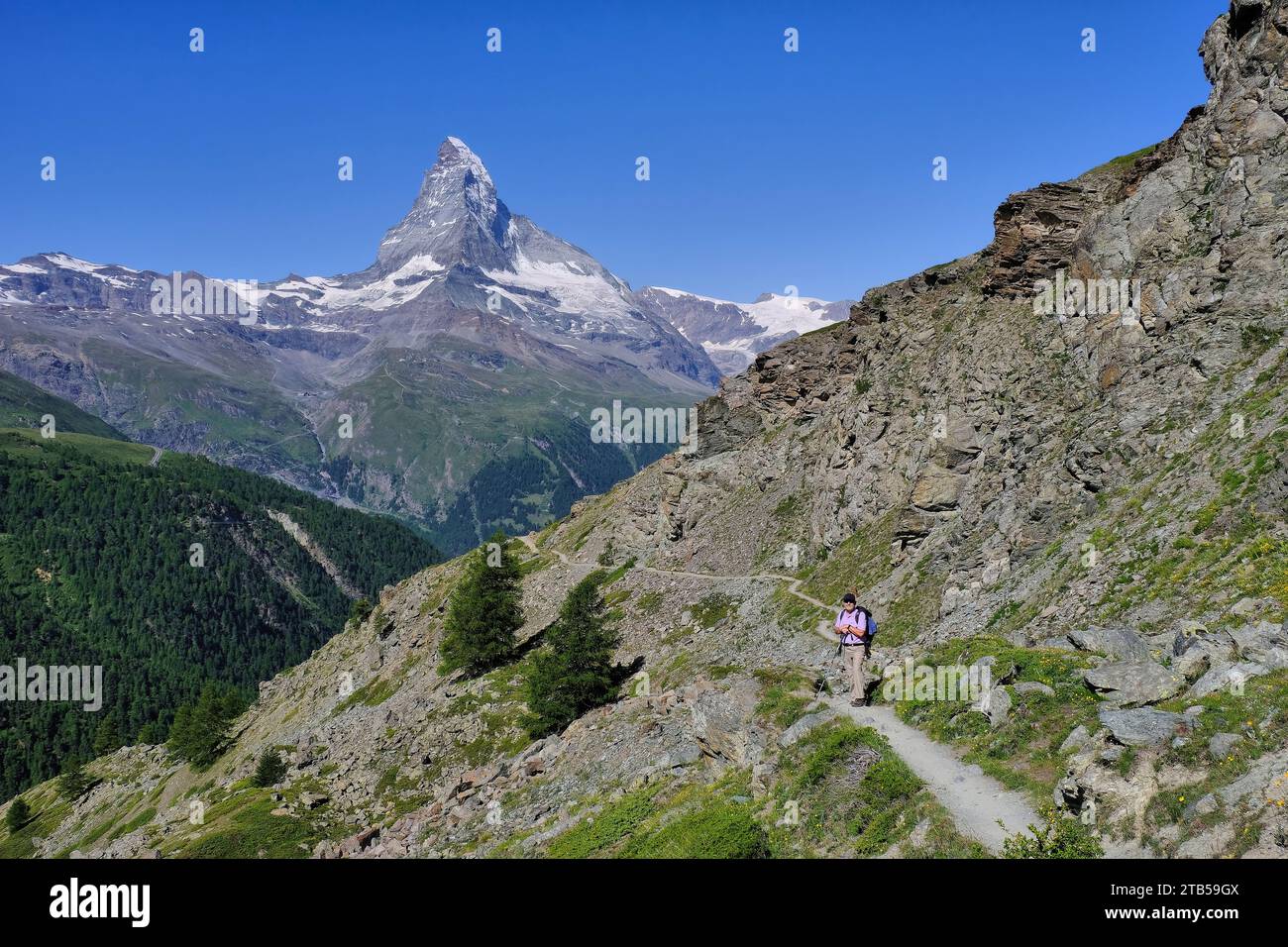 Escursionista su sentiero e Cervino con cielo nuvoloso vicino a Blauherd, Zermatt, Visp, Vallese, Svizzera Foto Stock