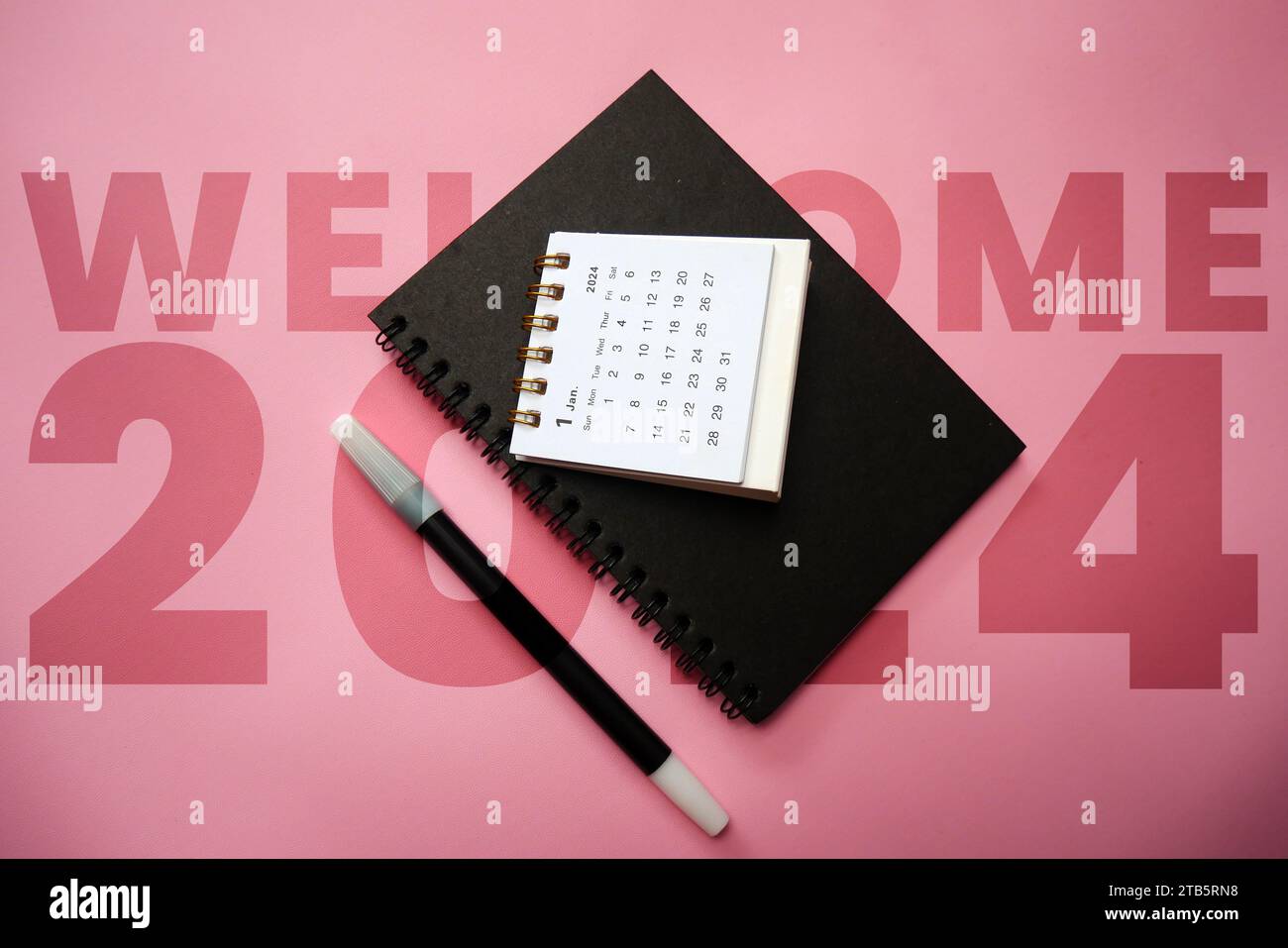 Benvenuto 2024. Gennaio 2024 calendario da scrivania isolato su sfondo rosa. Immagine simile sul mio portfolio. Foto Stock