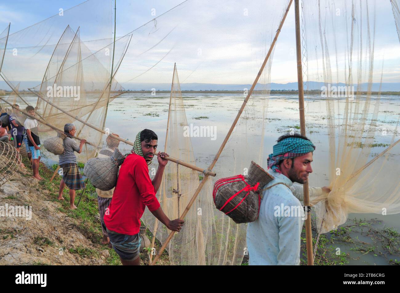Le popolazioni rurali armate di trappole e reti per pesci di bambù partecipano a un festival invernale di pesca di 200 anni presso la jofra beel of gasbari union di Kanaighat upazila di Sylhet, Bangladesh. Foto Stock