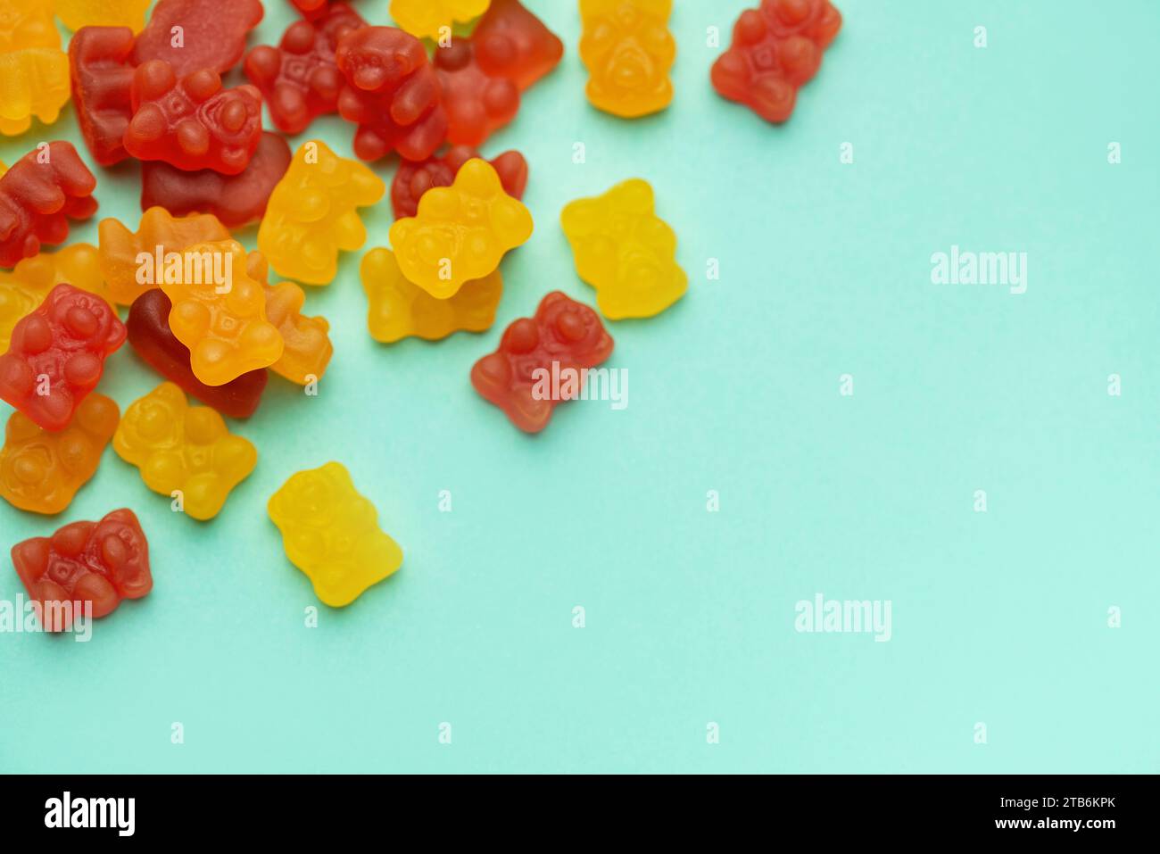 Vitamine per bambini, gelatina orso gommoso caramelle su sfondo verde pastello Foto Stock