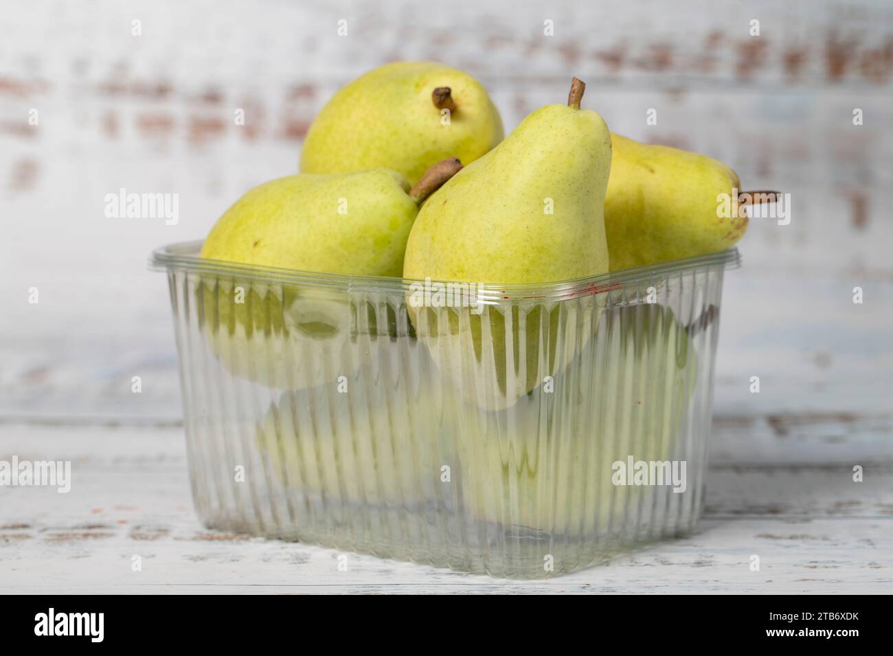 Pere confezionate su fondo di legno bianco. Prodotti agricoli biologici. Deliziose pere mature Foto Stock
