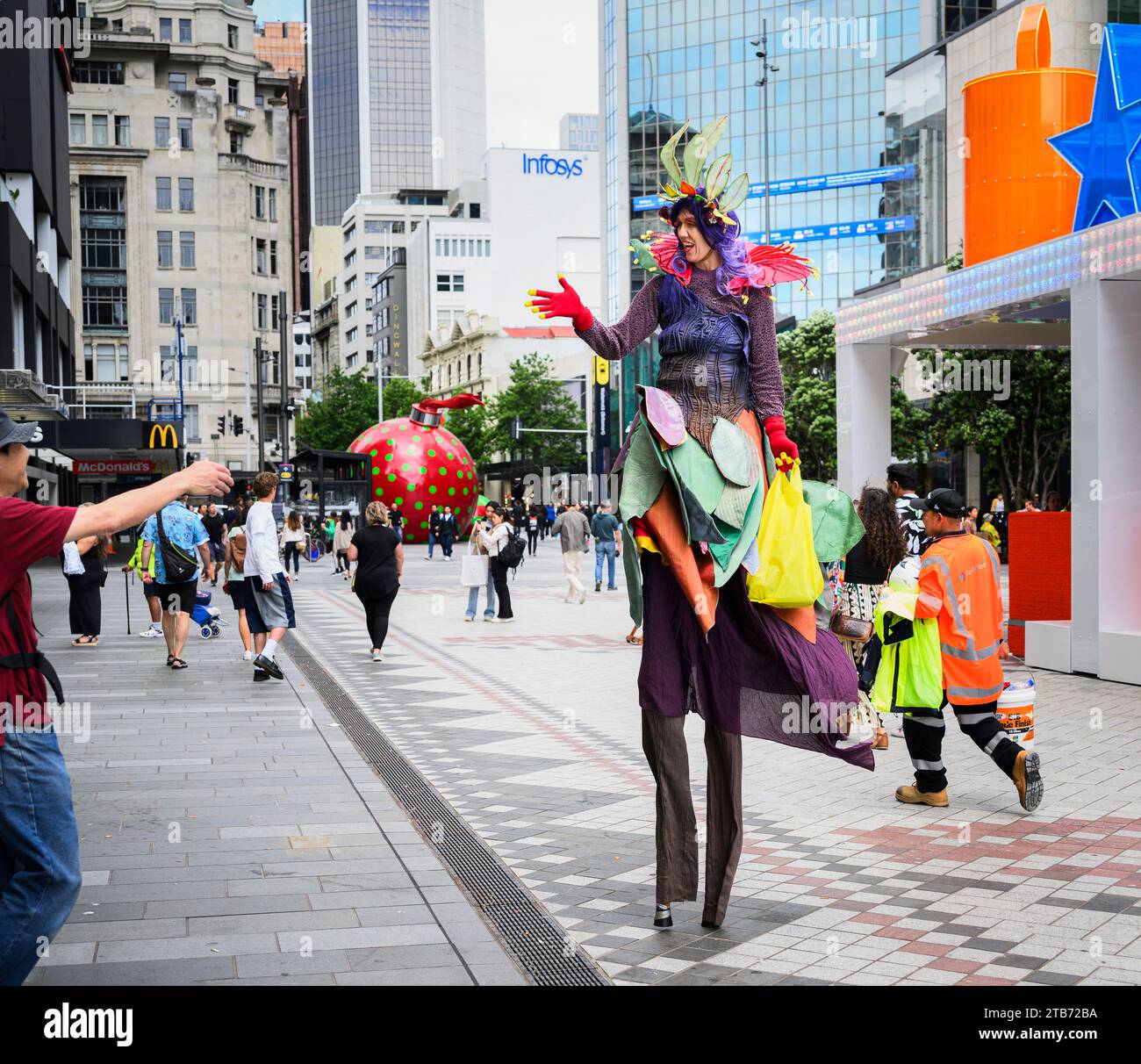 Una donna con trampolino saluta i pedoni al festival di Natale in Queen Street, nel centro di Auckland. Foto Stock