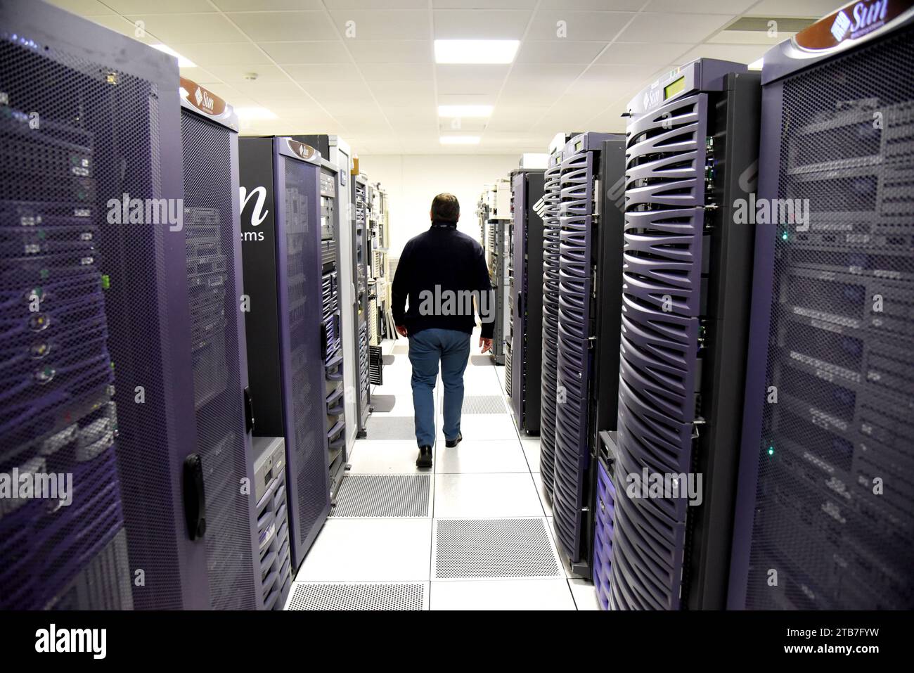 Azienda IT: Un tecnico visto da dietro nella sala server del microsistema Sun Foto Stock