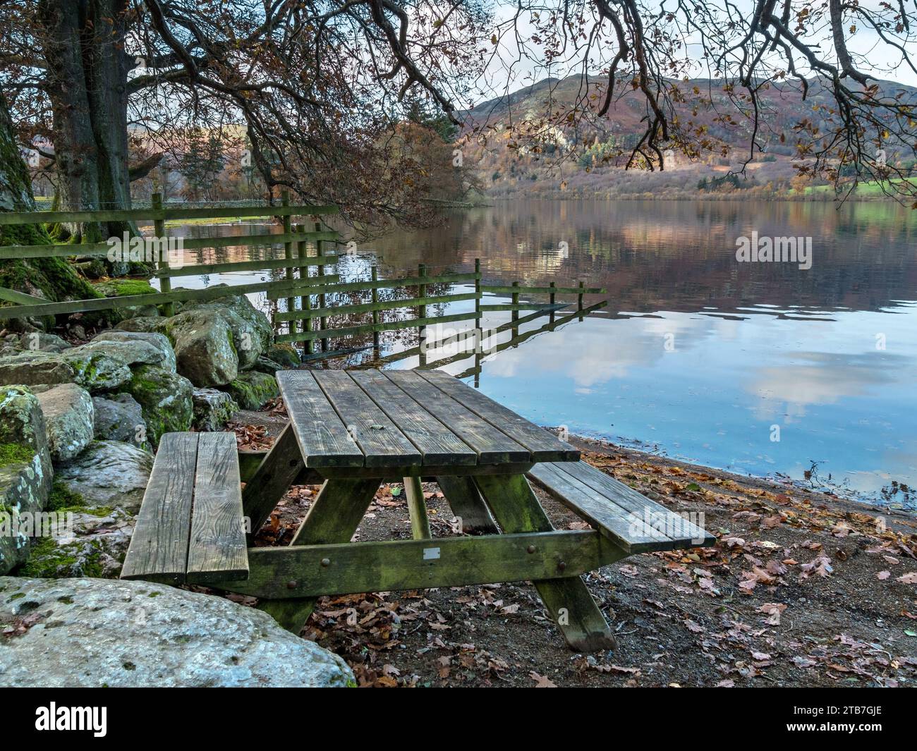 Tavolo da picnic sulla spiaggia sul lago Ullswater nell'English Lake District, visto da Sandwick in autunno, Cumbria, Inghilterra, Regno Unito Foto Stock