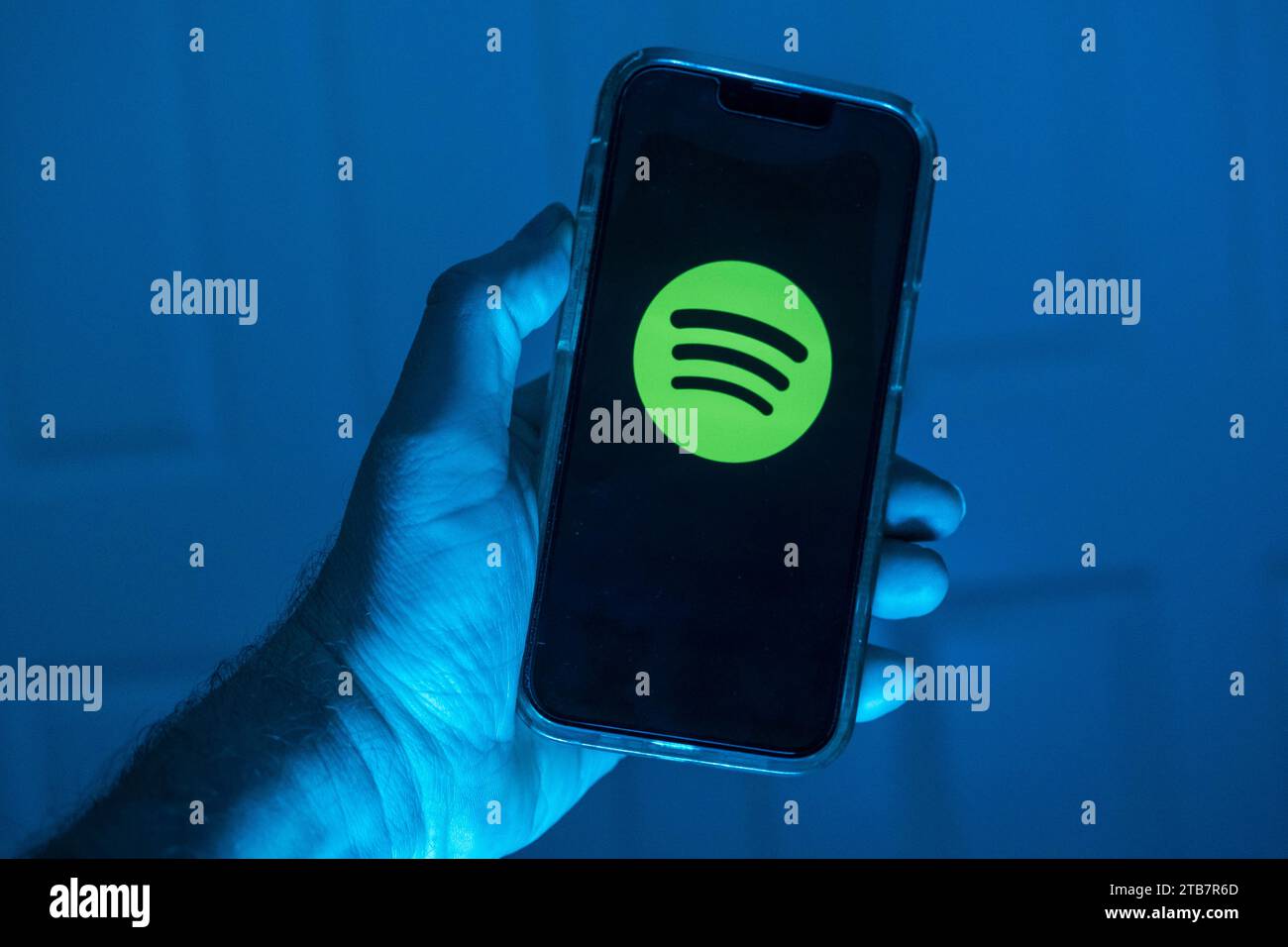 La mano contiene un telefono cellulare sul quale è riportato il logo del musi Foto Stock