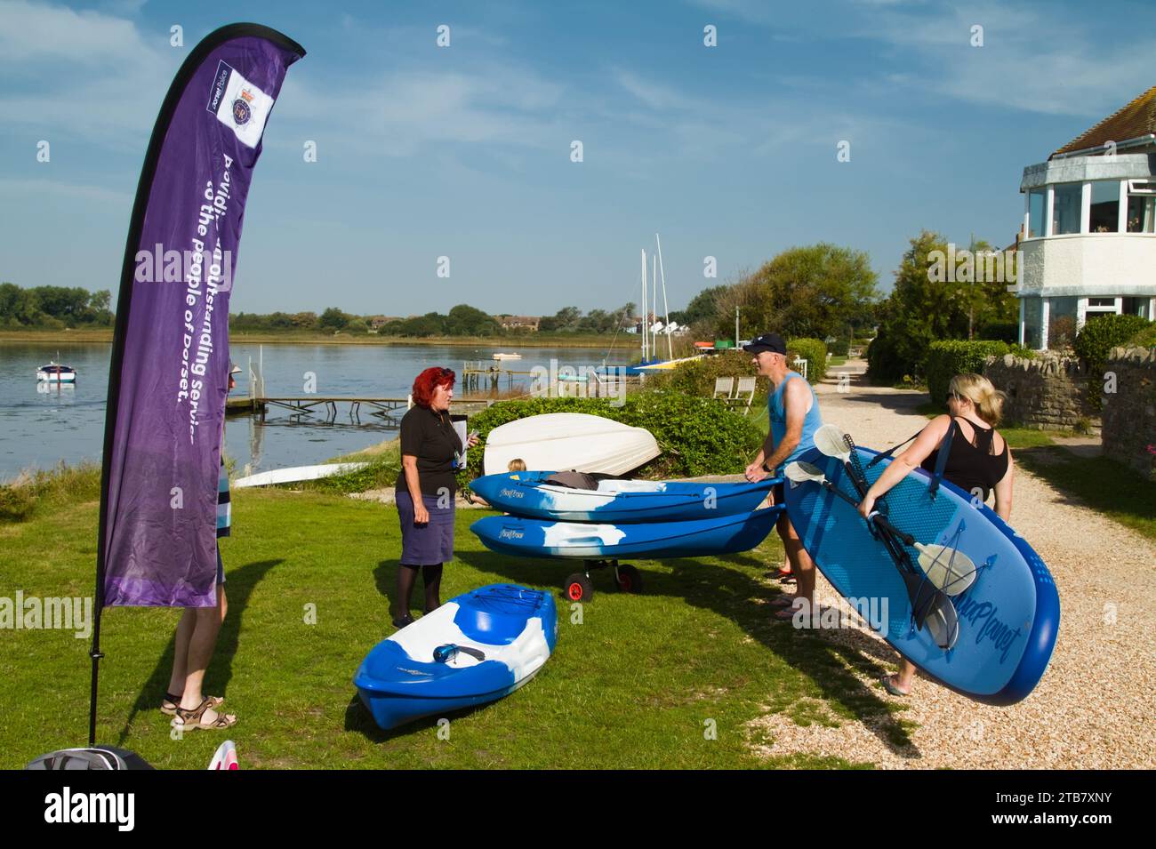 Persone che hanno i loro kayak e la loro moto d'acqua marchiati in modo sicuro dalla polizia del Dorset utilizzando la codifica del DNA per prevenire il crimine e il furto, Christchurch Harbour, Regno Unito Foto Stock