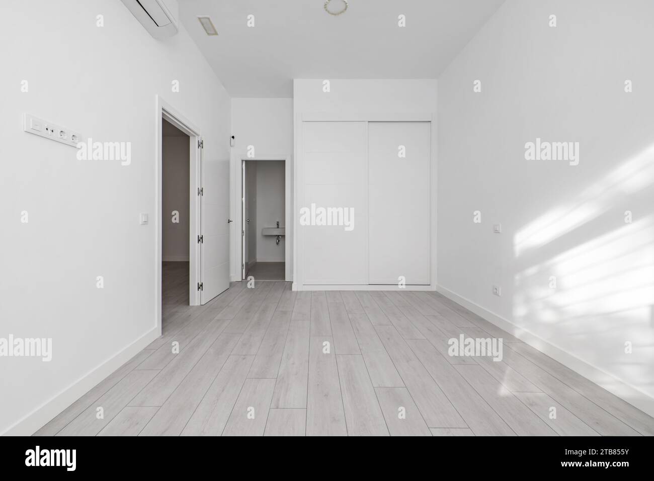 Camera da letto di una casa tipo loft con un guardaroba bianco a incasso Foto Stock