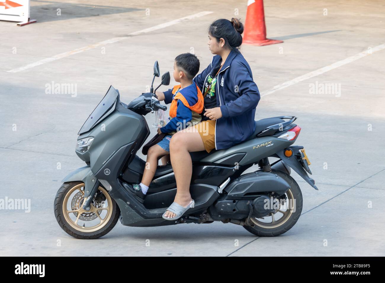 SAMUT PRAKAN, THAILANDIA, 03 novembre 2023, Una donna cavalca un ragazzo in moto. Foto Stock