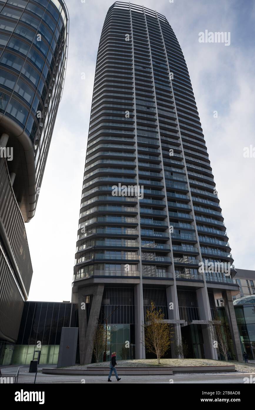 Una solitaria passeggiata pedonale vicino all'imponente Sky Park Tower, una testimonianza dell'ambizione architettonica moderna. La facciata ritmica dell'edificio e la sua vertiginosa altezza Foto Stock