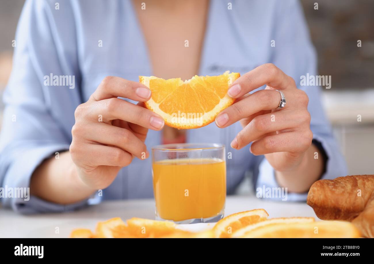 Bracci femmina tenere scorre arancione e il bicchiere di succo di frutta Foto Stock