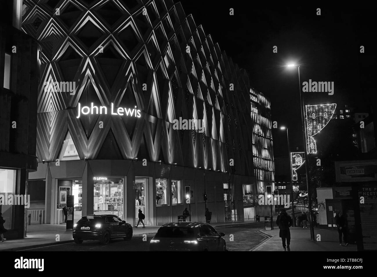Il grande magazzino John Lewis di sera, i dettagli architettonici risaltano in bianco e nero e le luci brillanti, Leeds, Inghilterra, Regno Unito. Foto Stock