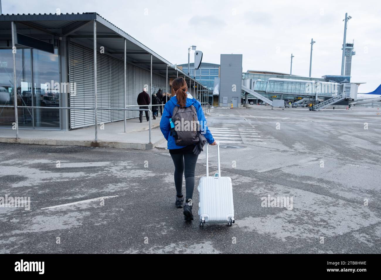 Una giovane turista che camminava con i bagagli è arrivata in pista all'aeroporto Foto Stock