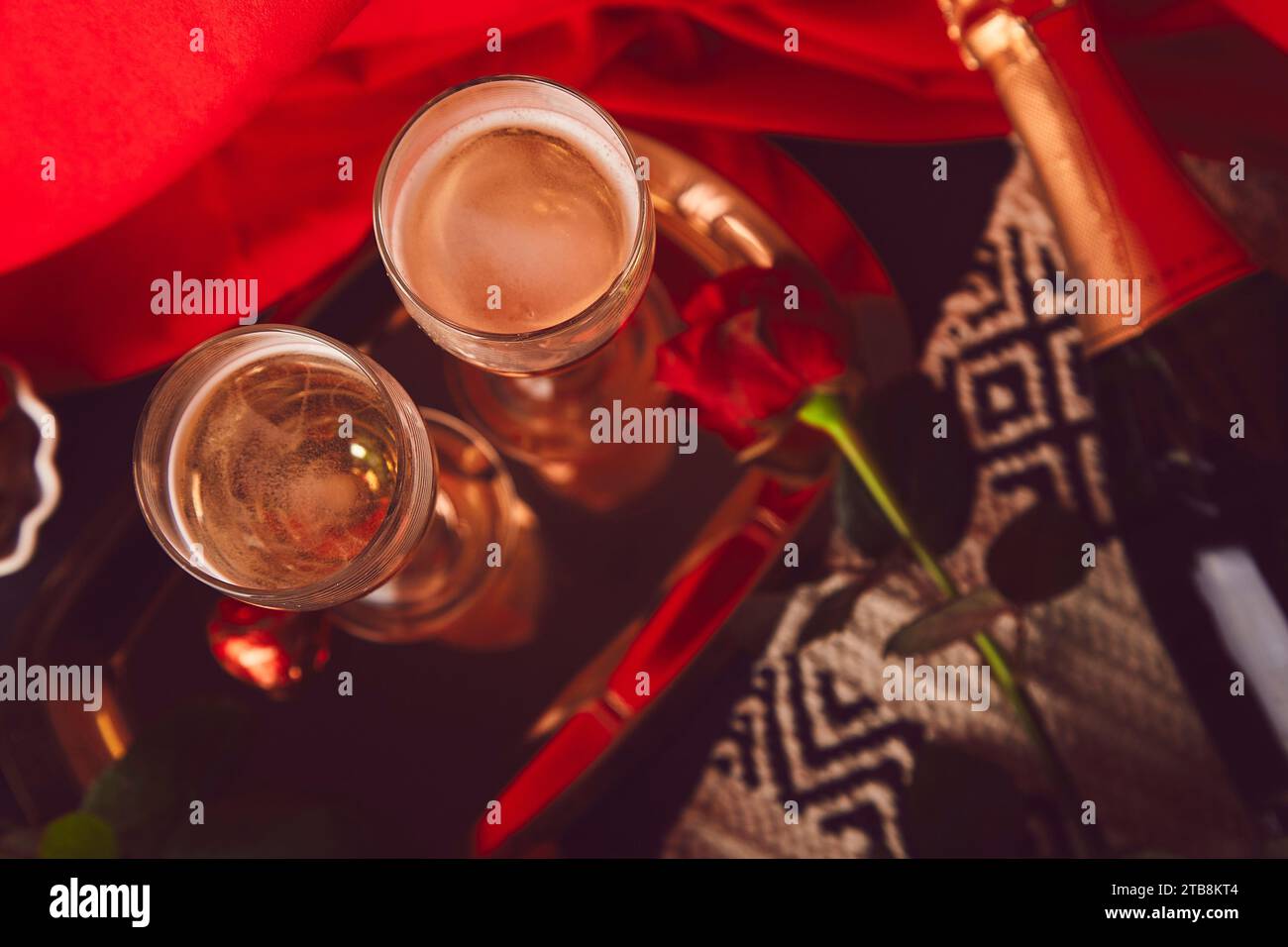 Tradizionale tavolo di San Valentino. Rose rosse, champagne, caramelle di cioccolato - cena romantica stagionale a base di piatti. Foto Stock