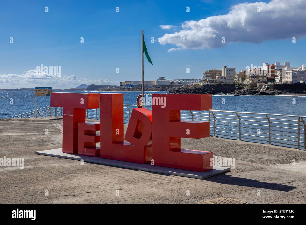 Gran Canaria, Spagna - 24 novembre 2023: Grandi lettere rosa del Telde Village nel Melenara Dock e passeggiata con bandiera verde dei nuotatori. Foto Stock