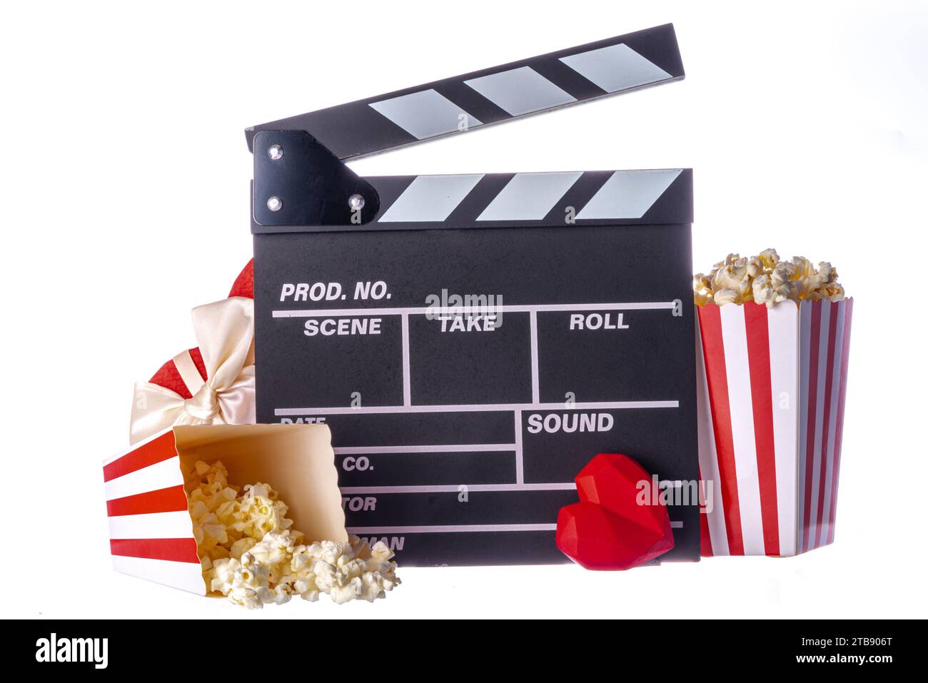 Appuntamento romantico il giorno di San Valentino 14 febbraio. Maratona di film d'amore, appuntamento al cinema. Clapperboard, secchi di popcorn, decorazioni a cuore e cioccolatini Foto Stock