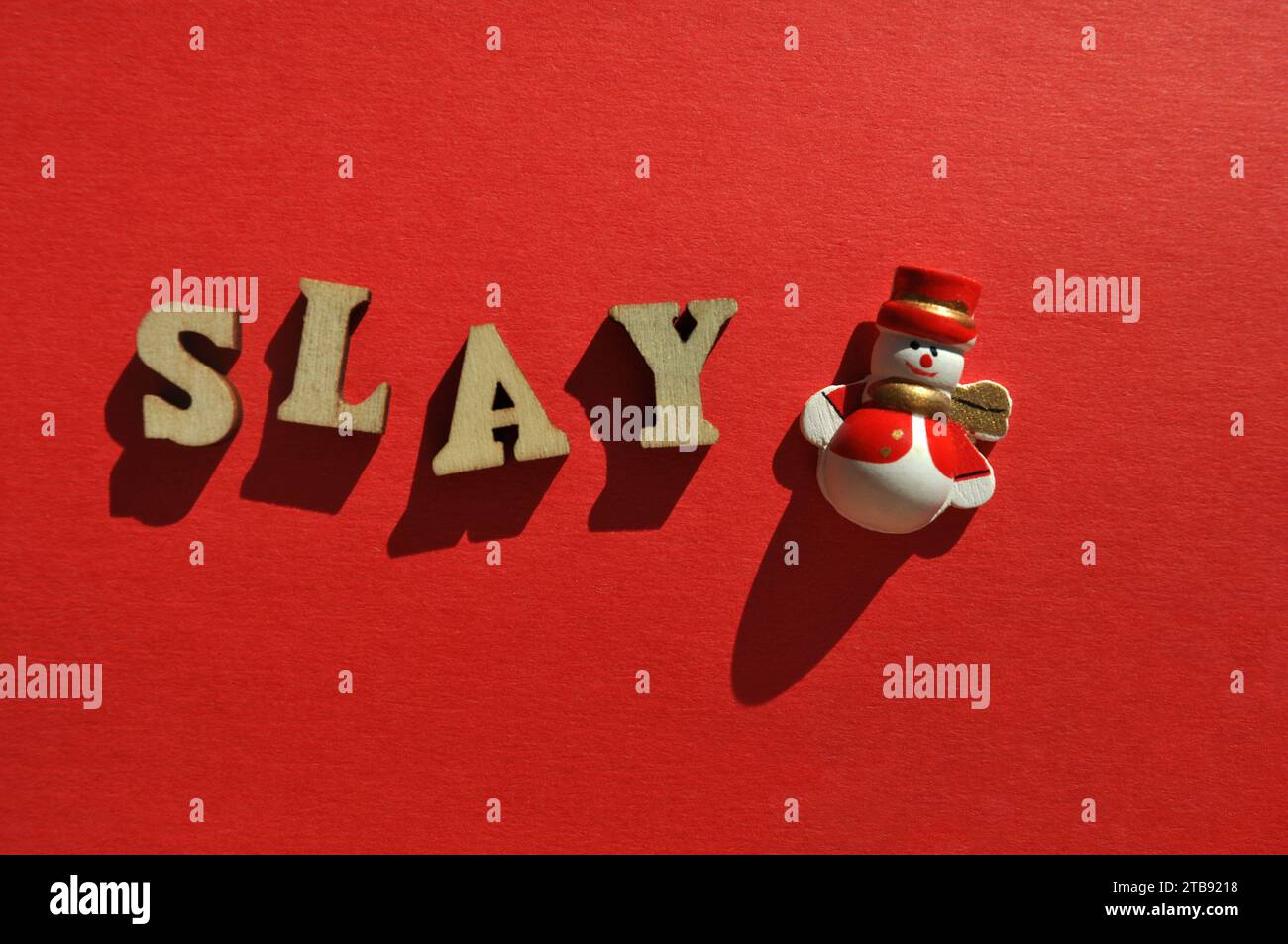 Uccidi, parola in lettere alfabetiche di legno con graziosa decorazione di pupazzi di neve natalizi, concetto creativo Foto Stock