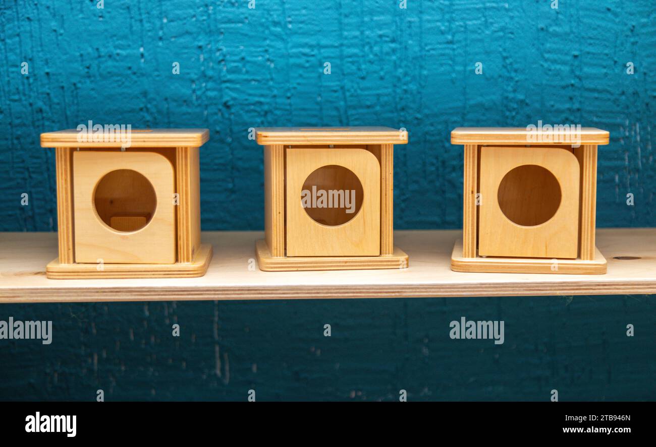 Primo piano di tre scatole montessori quadrate in legno su uno scaffale Foto Stock