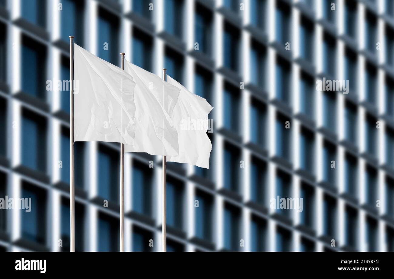 Tre bandiere aziendali bianche che sventolano nel vento contro un edificio sfocato per uffici. Modello di flag vuoto per aggiungere qualsiasi logo, simbolo o segno Foto Stock