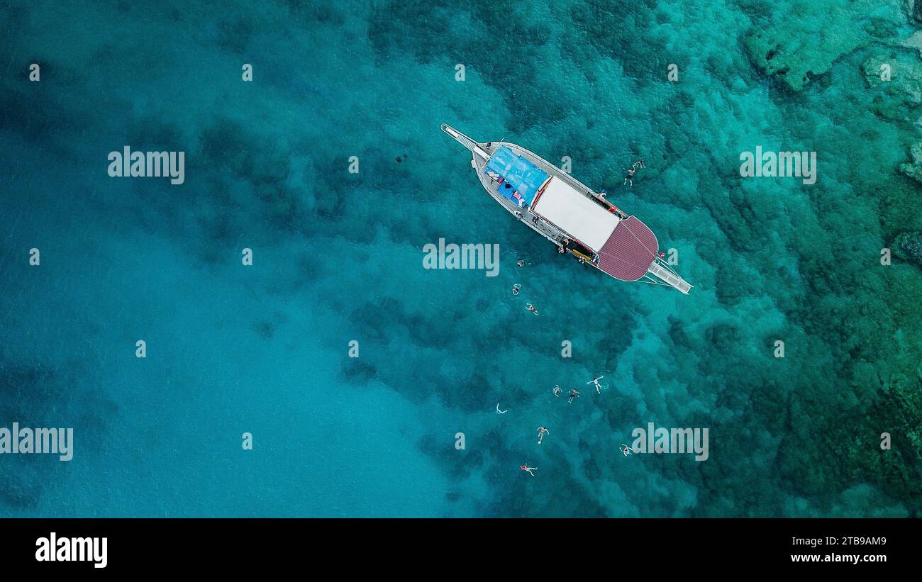 Vista aerea dell'uomo che nuota nell'acqua turchese dell'oceano Foto Stock