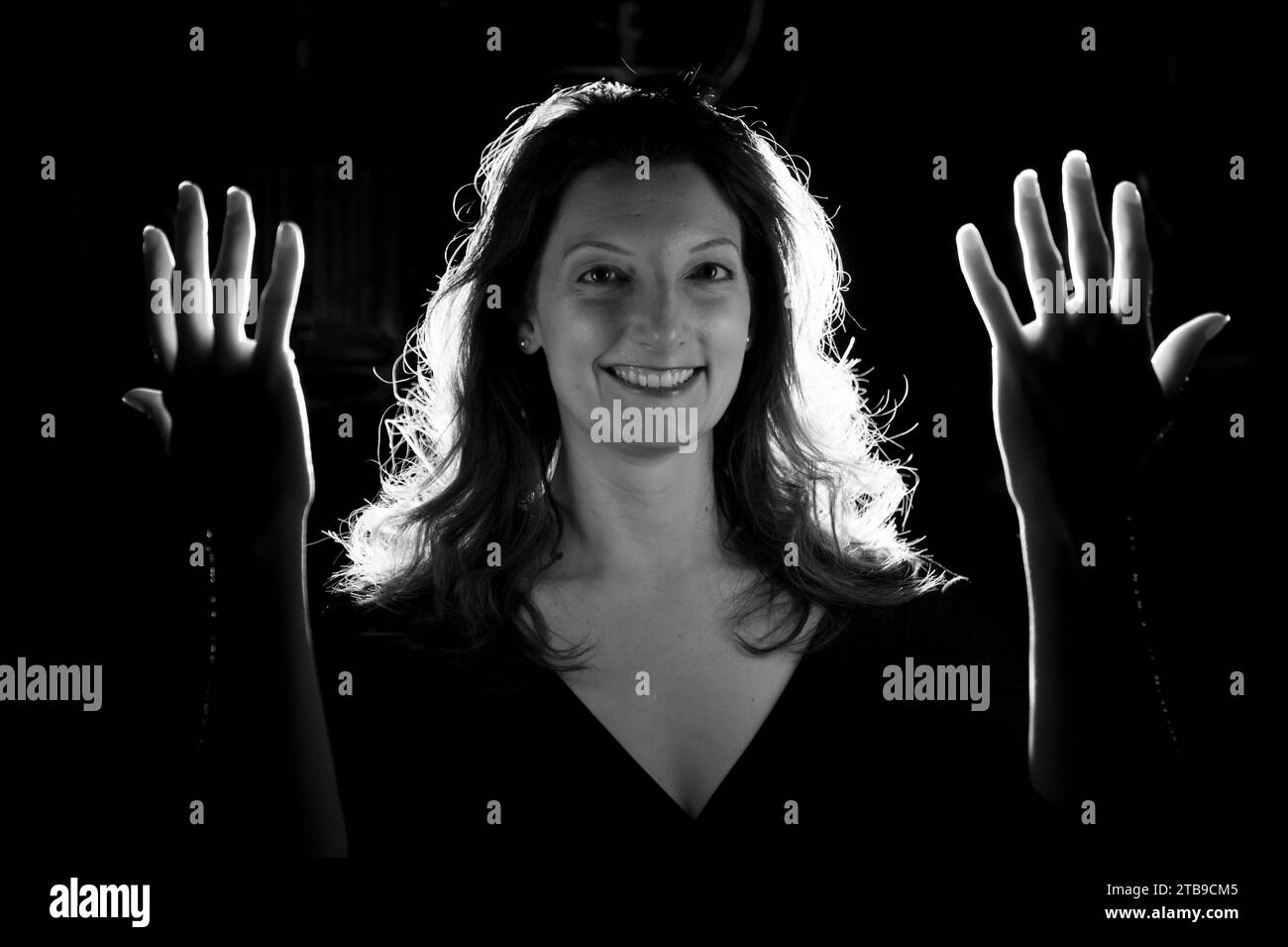 Giovane donna tiene le mani nella luce illuminante; Lincoln, Nebraska, Stati Uniti d'America Foto Stock