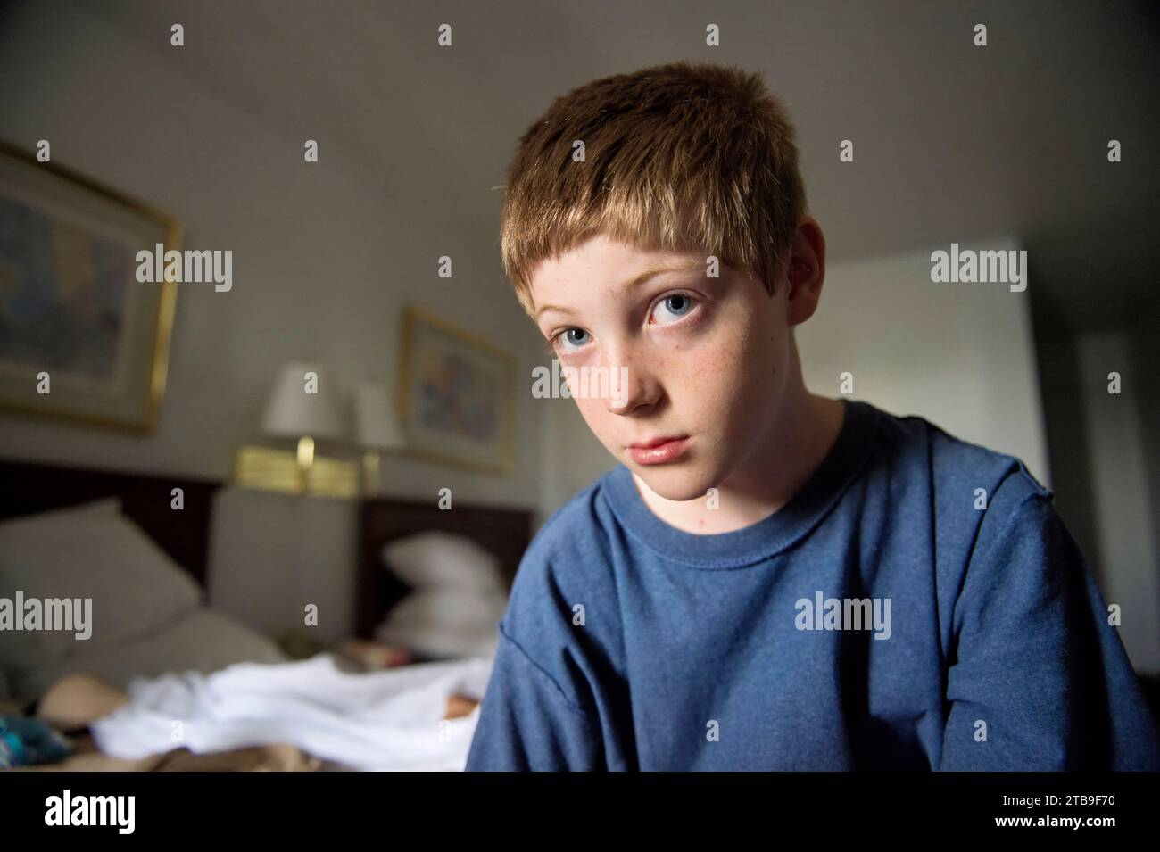 Ragazzo siede in una camera d'albergo; Iowa, Stati Uniti d'America Foto Stock