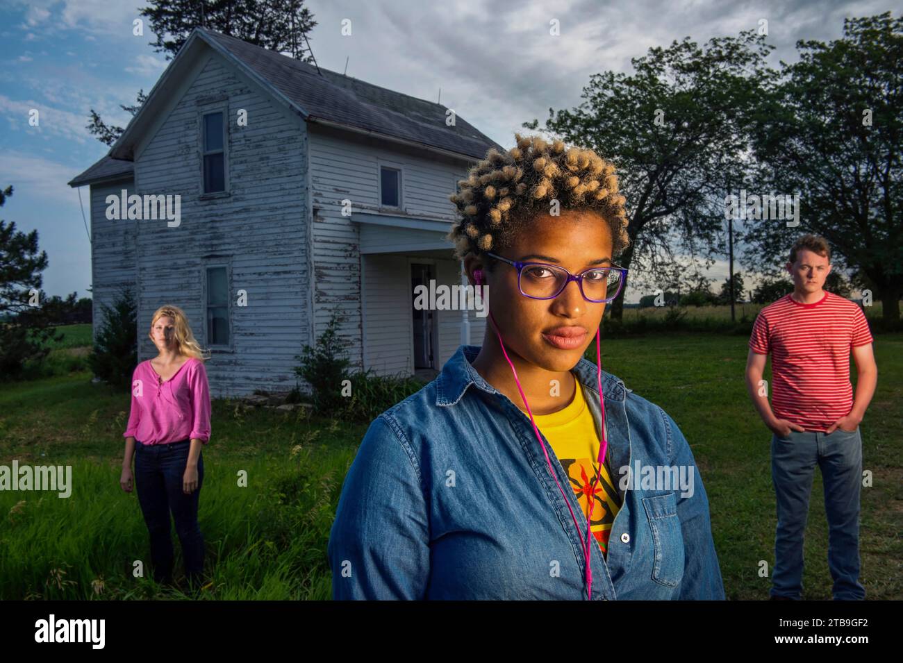 Tre giovani adulti stanno fuori da una vecchia fattoria; Bennet, Nebraska, Stati Uniti d'America Foto Stock