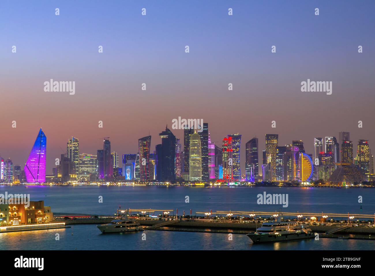 Lo skyline della capitale Doha e il quartiere degli affari al calar della notte; Doha, Qatar Foto Stock