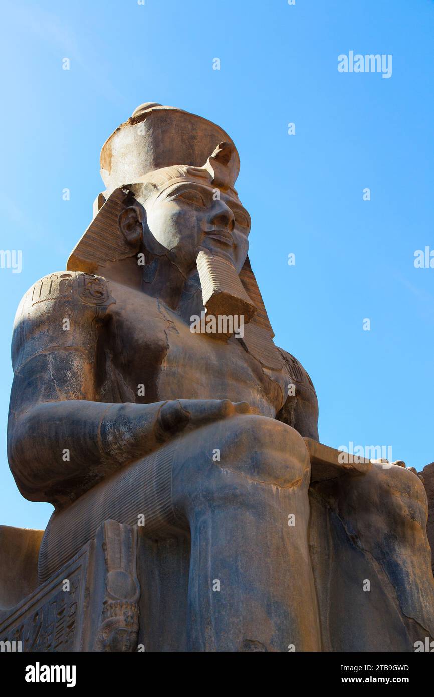 Primo piano della statua di Ramsete II contro un cielo blu all'esterno dell'antico tempio egizio; Luxor, Egitto Foto Stock