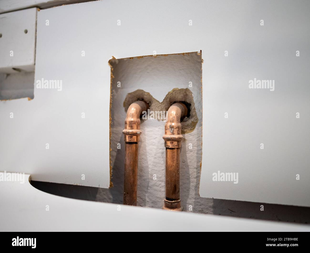 Tubi di rame per l'acqua in un appartamento. Le tubazioni sono installate nella cucina dell'appartamento. Sono importanti per il riscaldamento e per l'acqua calda. Foto Stock