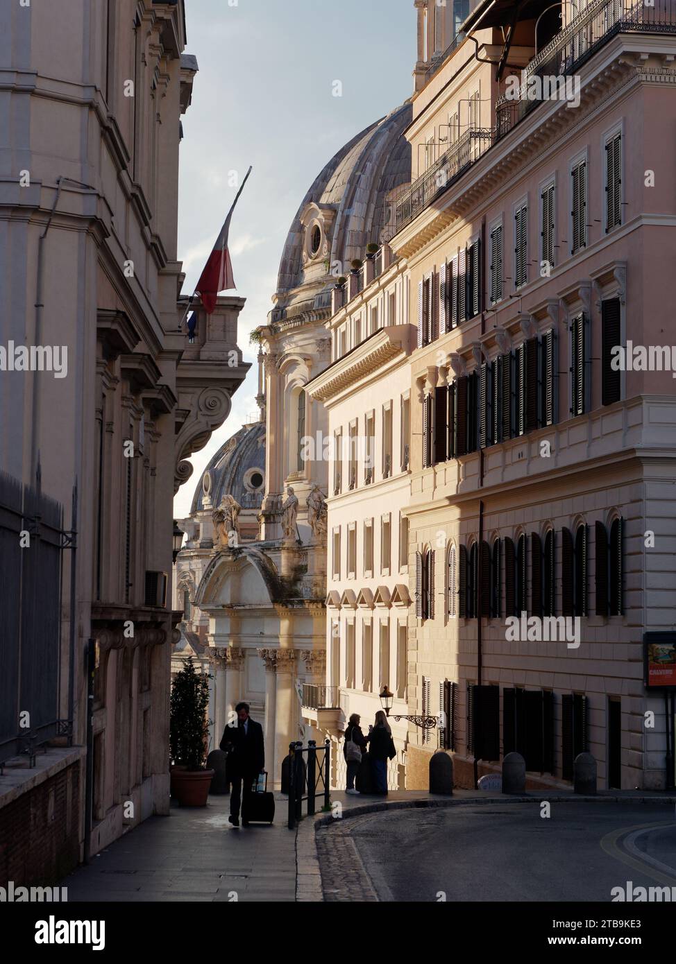 Pedoni con la cupola della Chiesa del Santissimo nome di Maria alle spalle del foro Traiano. Roma, regione Lazio, Italia, dicembre Foto Stock