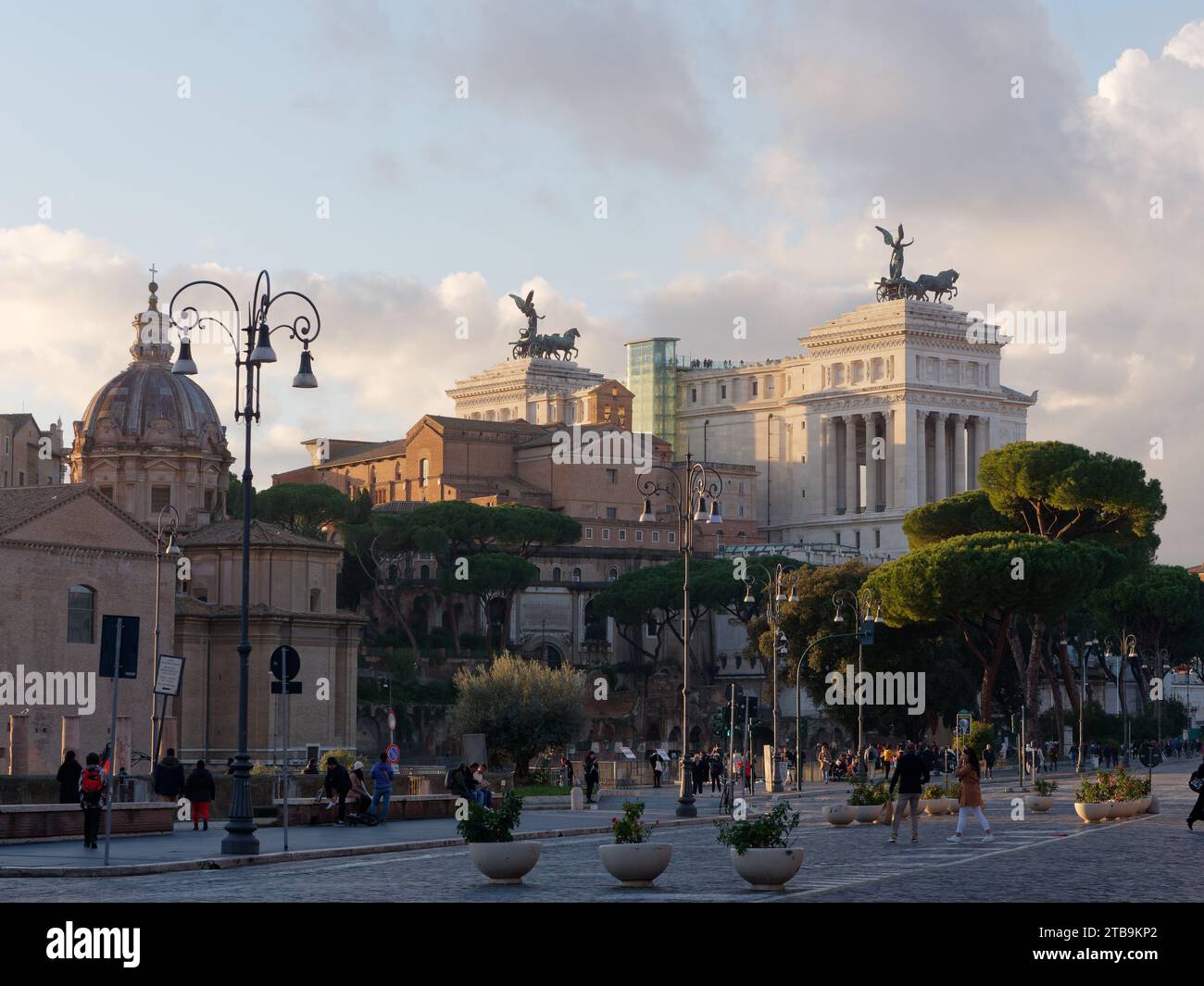 Monumento a Vittorio Emanuele II e altri edifici storici con pedoni e pini di pietra. Roma, regione Lazio, Italia, 05 dicembre 2023 Foto Stock