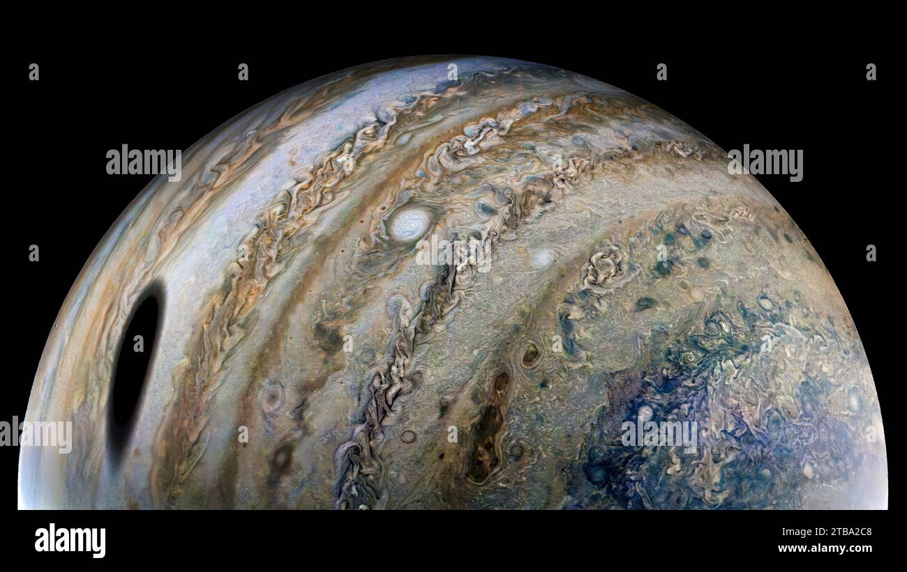 Pianeta Giove con una grande ombra scura sul lato sinistro, lanciata dalla sua luna Ganimede. Foto Stock