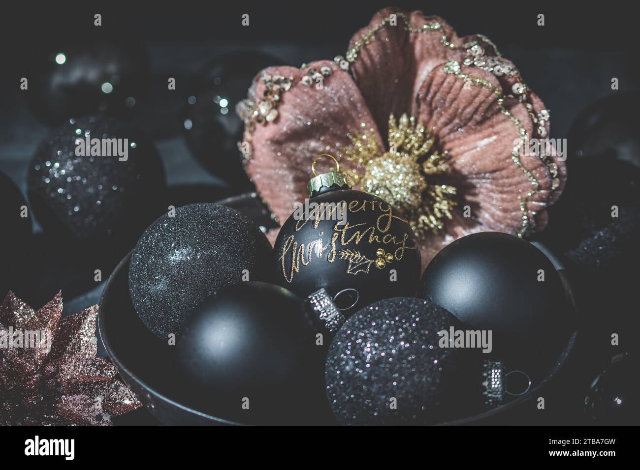Bauble nero con testo buon Natale, bauble nero e oro e altre decorazioni natalizie. Foto Stock