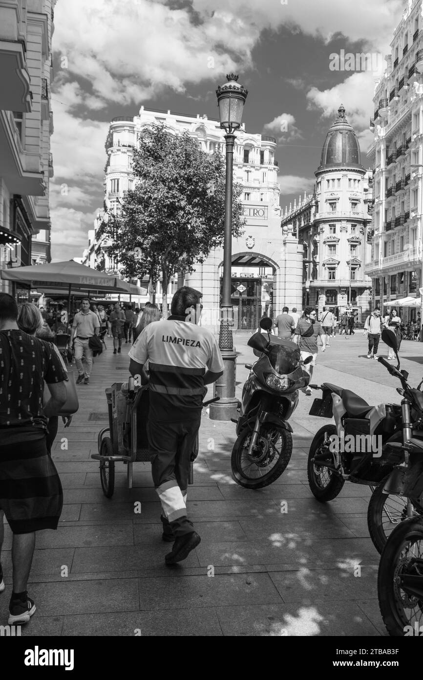 Lavoratore di pulizie stradali che cammina con un carrello per le strade di Madrid vicino alla Gran via, Spagna Foto Stock